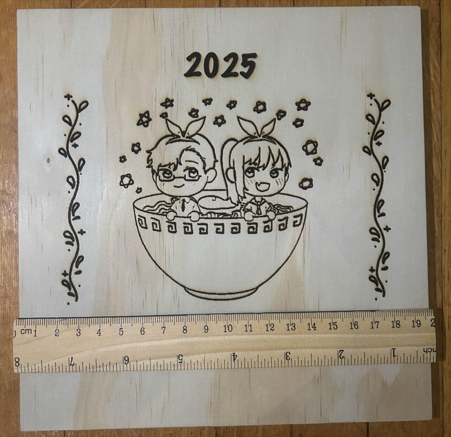 Engraved 2025 board with two chibi characters in a ramen bowl