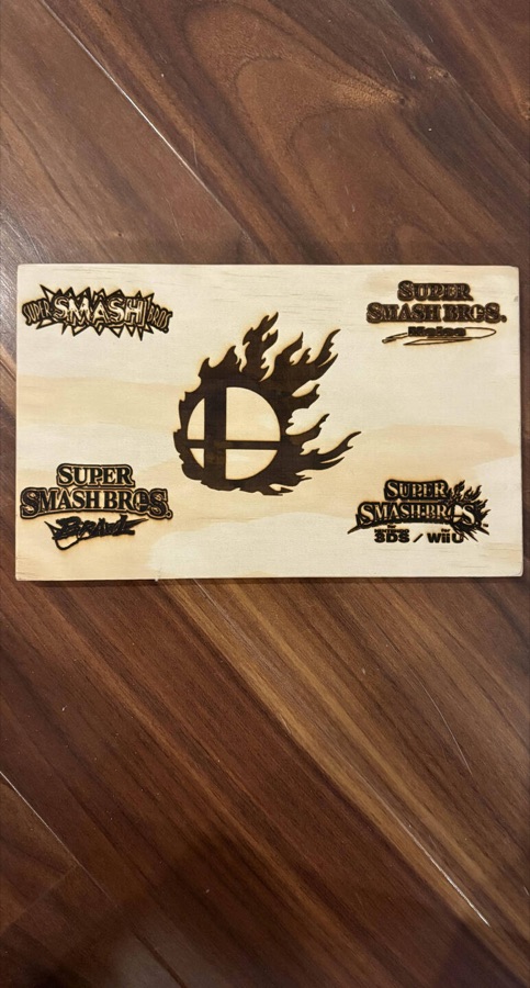Engraved board with Super Smash Bros logos through the years