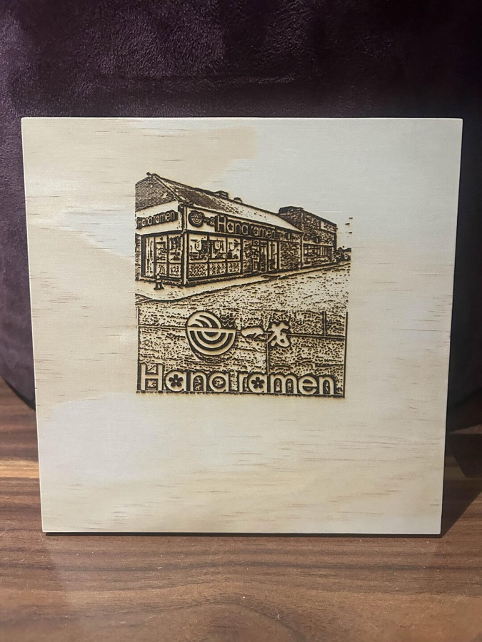 Engraved board of the Hanaramen restaurant storefront and logo
